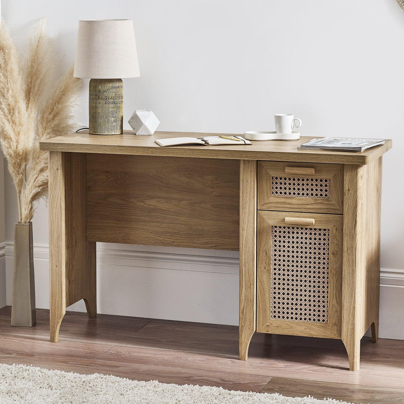 Rattan effect desk with two drawers, natural wood finish, styled with lamp and decor