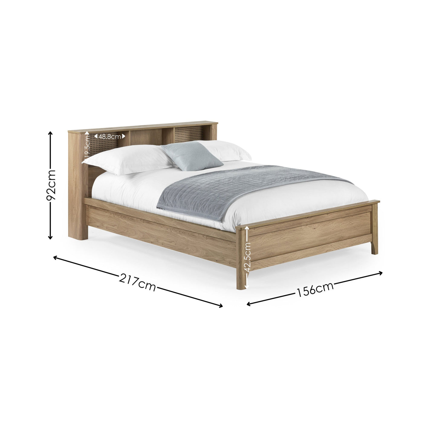 Natural wood double bed with rattan inset storage shelves in headboard, white bedding and grey throw, angled view