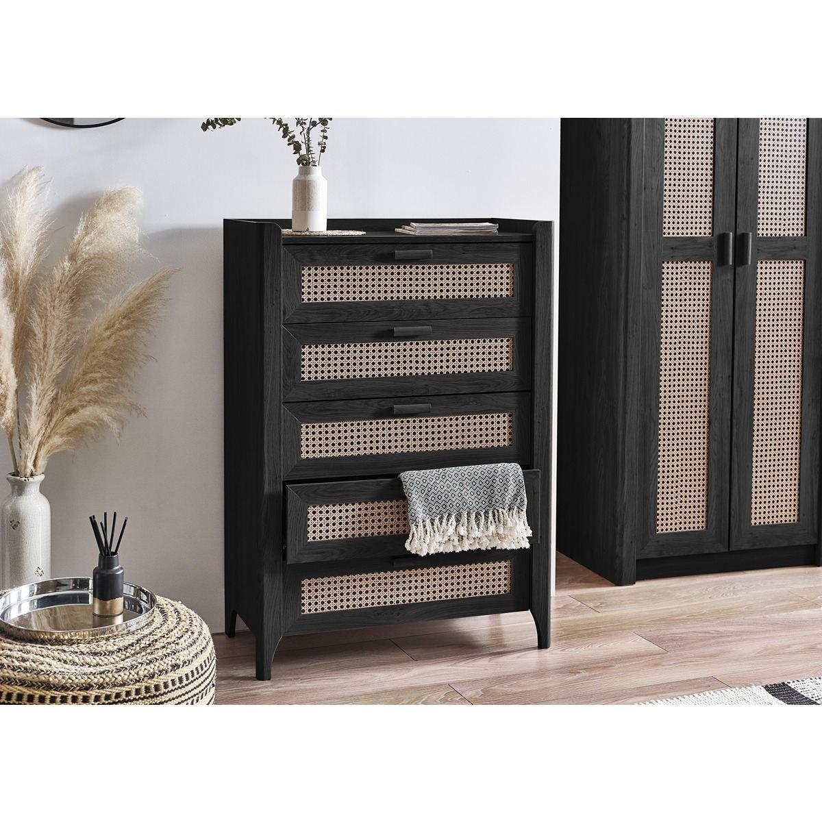 Black wood chest of drawers with rattan fronts in modern bedroom setting