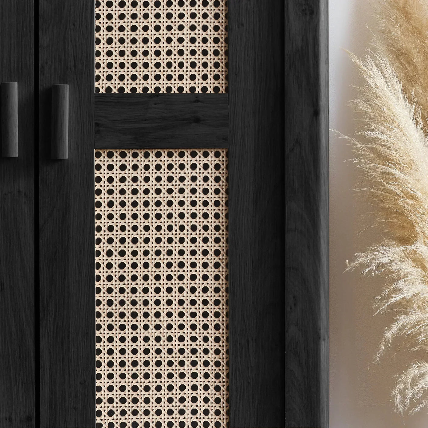 Close-up of black rattan effect wardrobe doors with woven panel and pampas grass decor