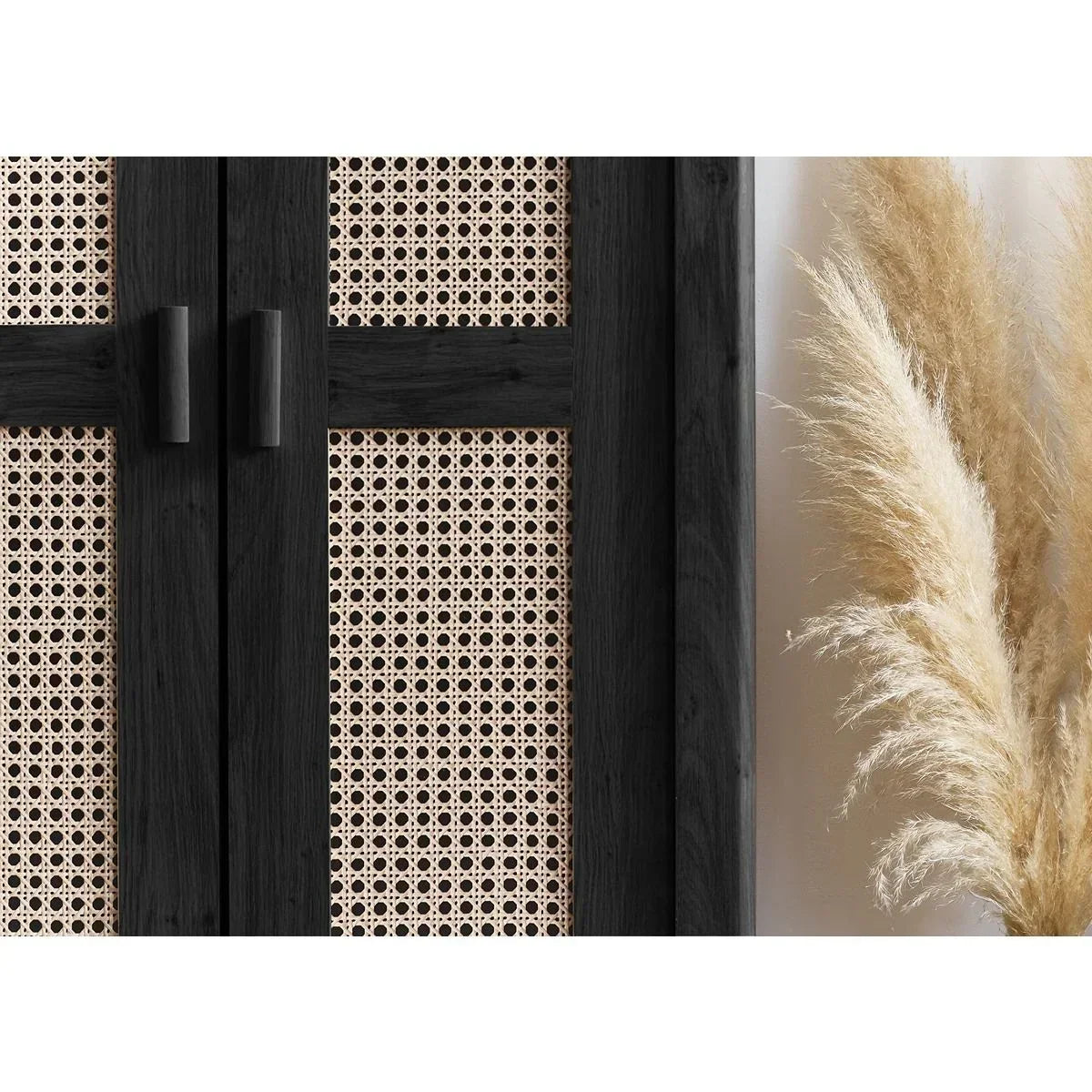 Black wood rattan cabinet door with cane panel detail beside pampas grass decor