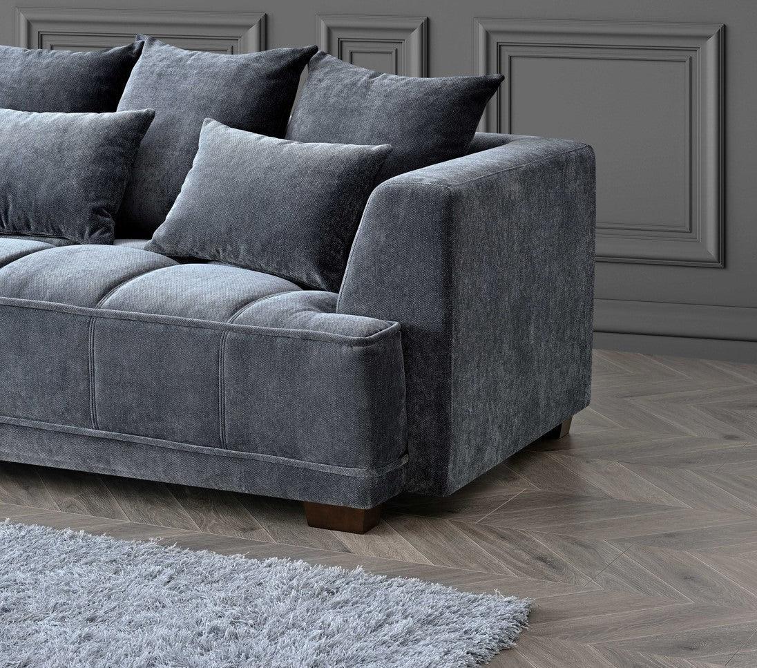 Grey fabric sofa with plush cushions on wooden floor beside shaggy rug