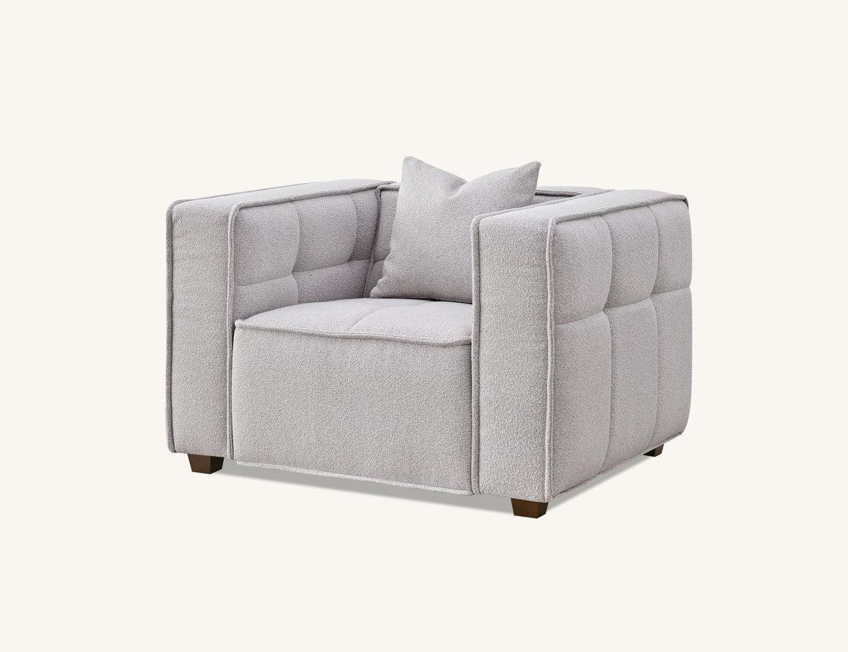Light grey upholstered armchair with tufted sides and matching cushion