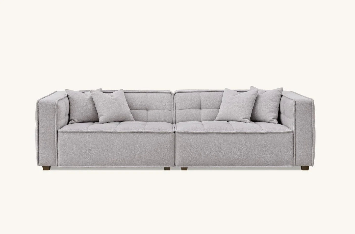 Light grey fabric sofa with tufted seat and four matching scatter cushions, front view