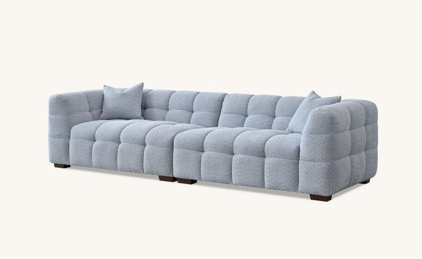 Light grey corner sofa with soft tufted upholstery and two matching cushions