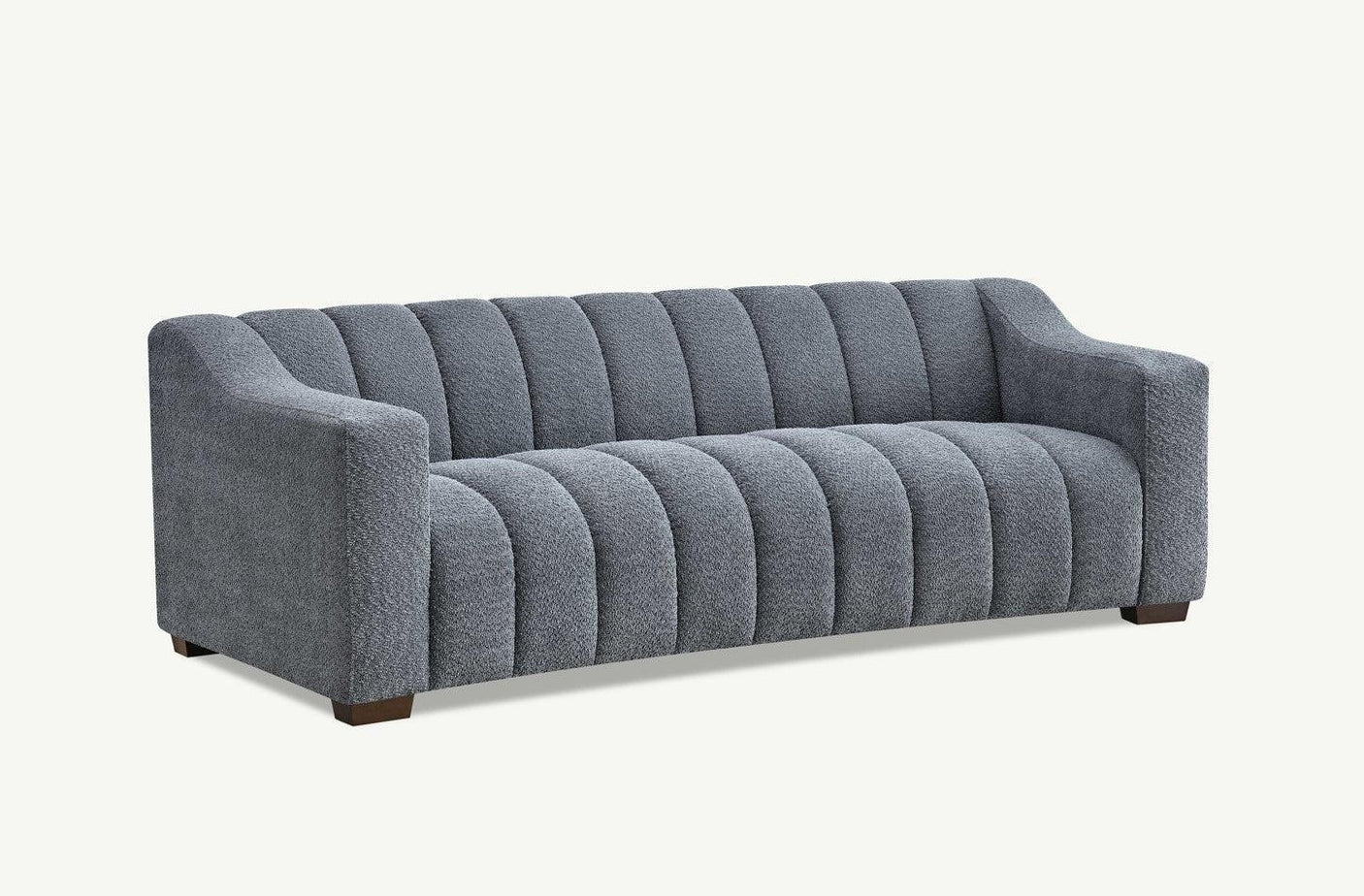 Grey fabric sofa with vertical channel tufting and low block legs, angled front view