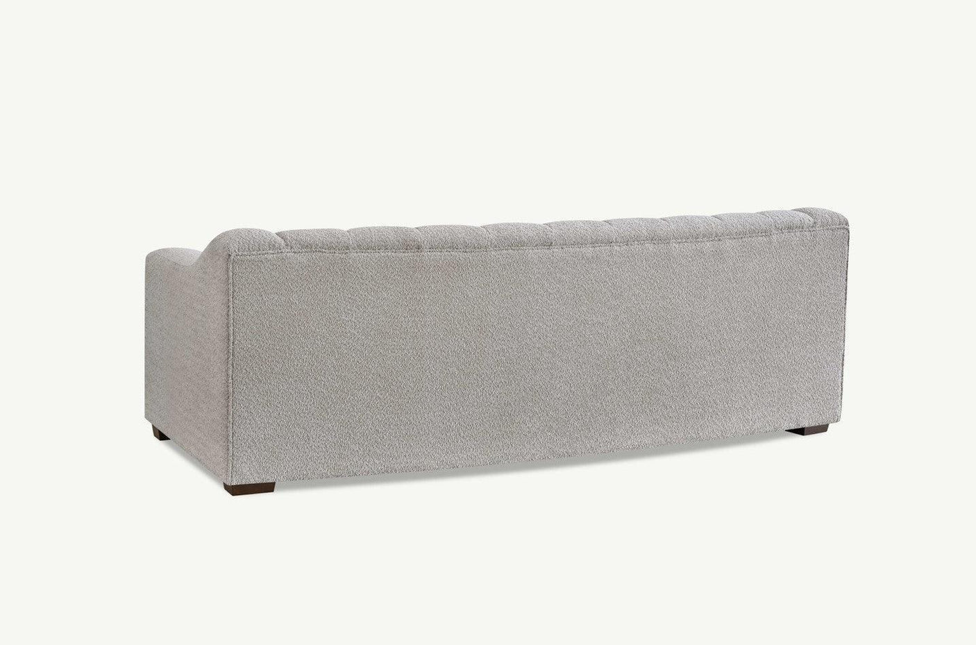 Back view of a grey fabric sofa with wooden feet and tufted detail