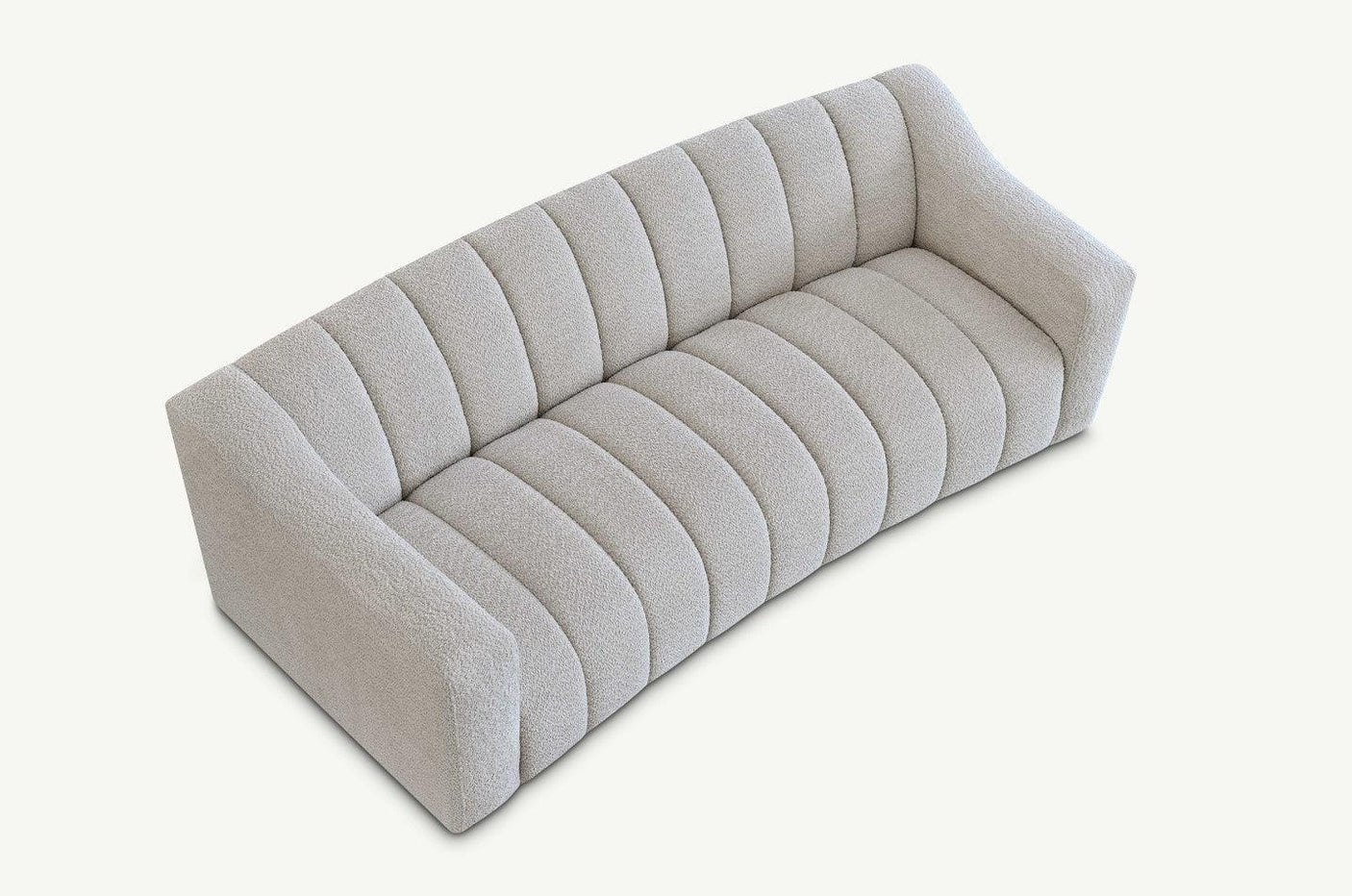 Curved beige fabric sofa with channel tufted seat and backrest, angled top view
