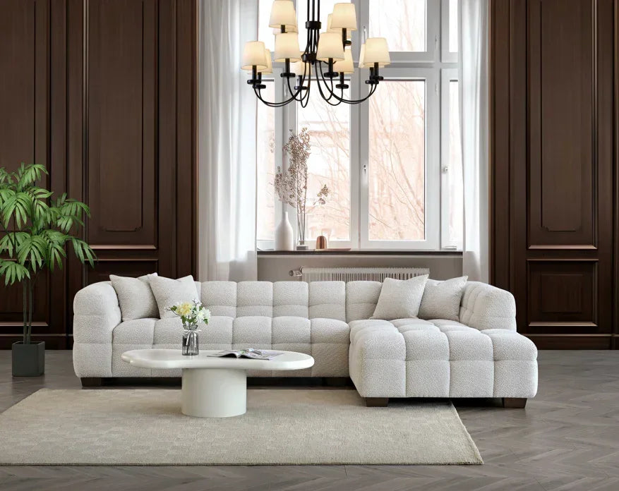 White corner sofa with tufted upholstery and chaise in modern living room with wood panel walls