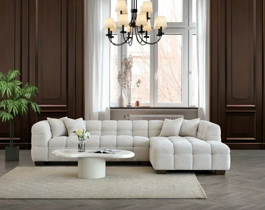 Modern cream fabric corner sofa set with cushions in elegant living room, coffee table in front