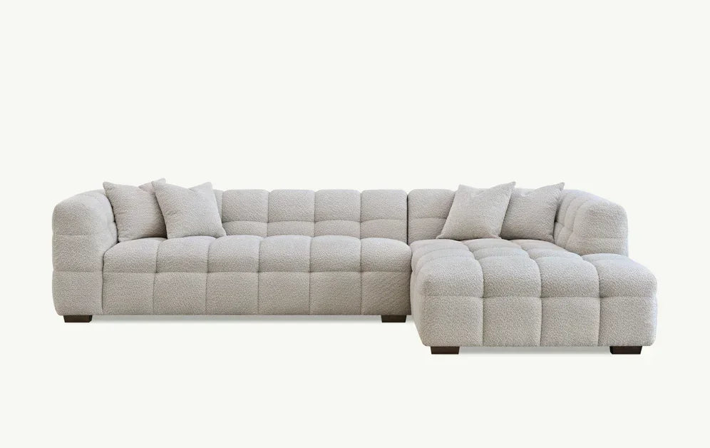 Light grey corner sofa with tufted upholstery and matching scatter cushions