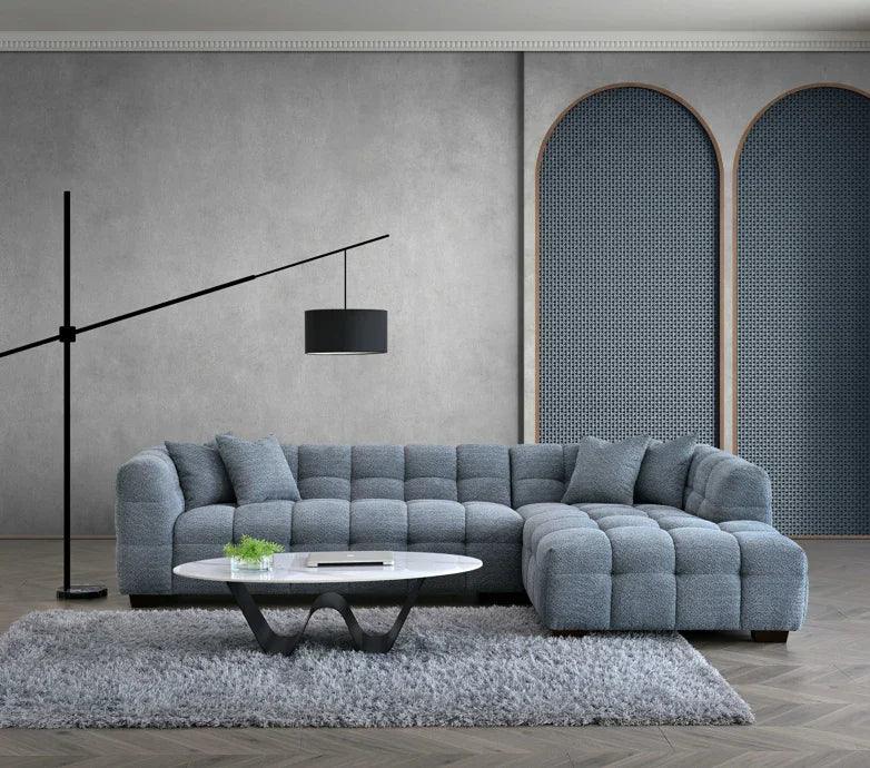Grey fabric corner sofa with tufted cushions beside modern coffee table on soft rug