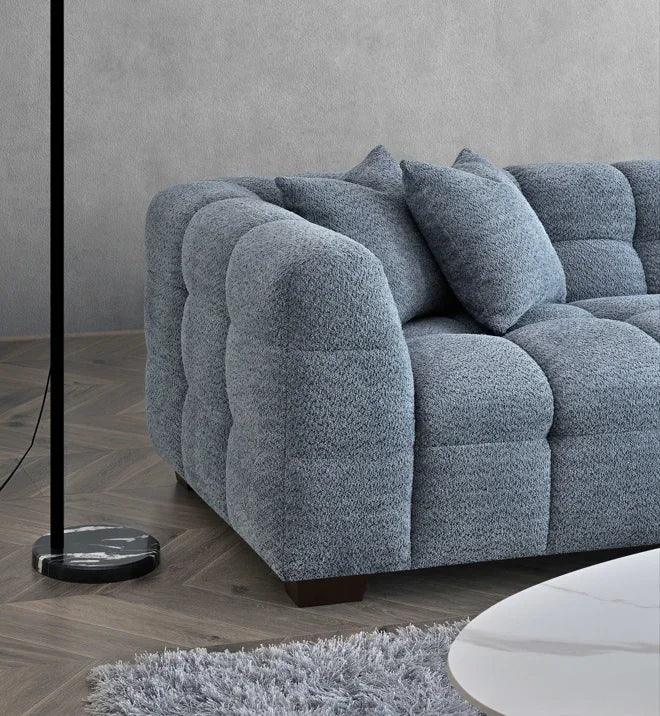 Grey textured fabric sofa with plush cushions in modern living room setting