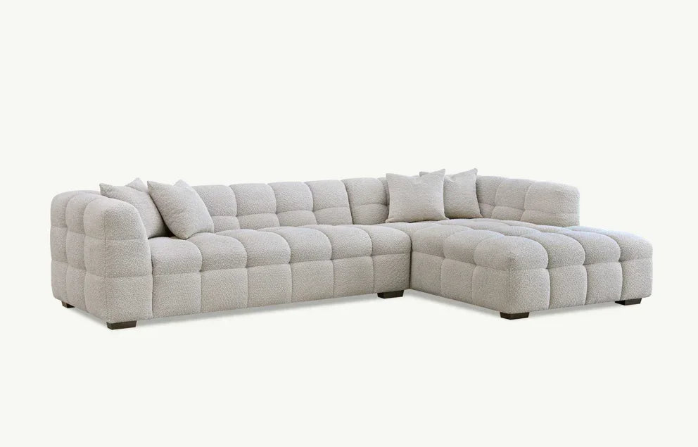 Light grey corner sofa with deep tufting and matching scatter cushions