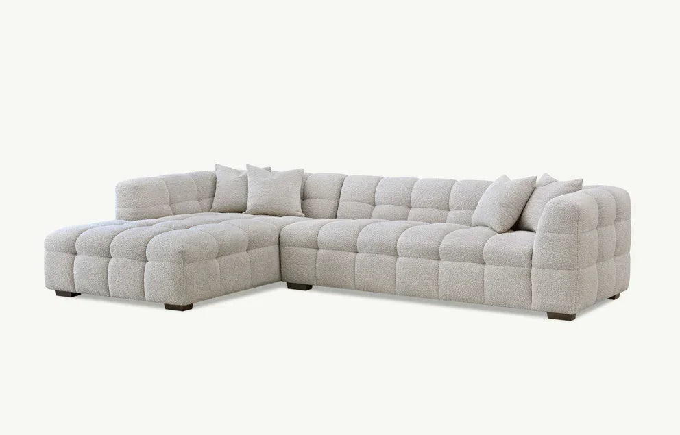 Light grey corner sofa with tufted upholstery and matching scatter cushions