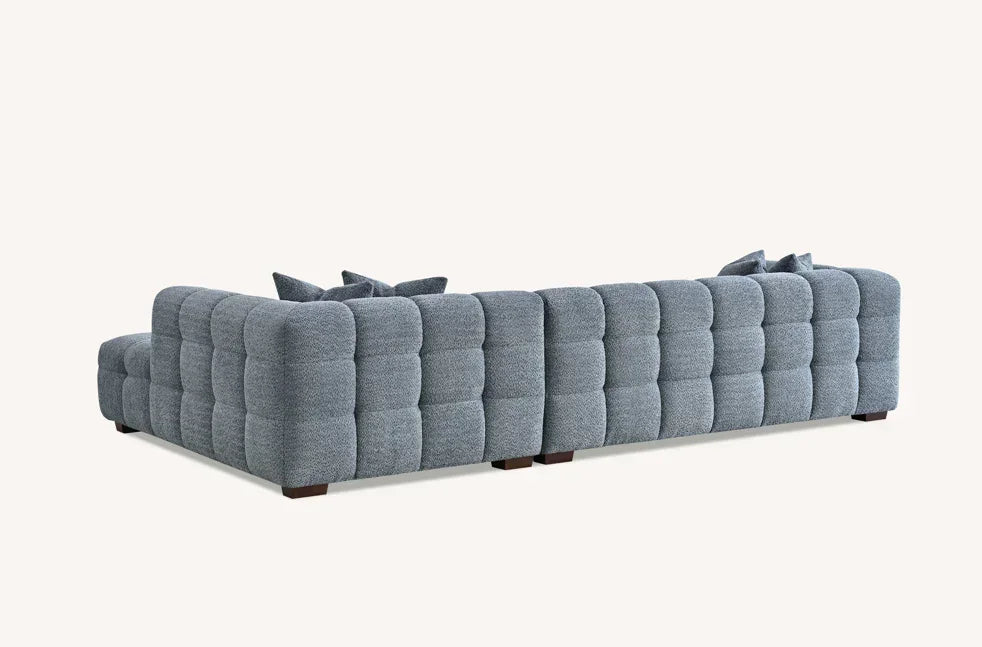 Grey fabric corner sofa with deep button tufting and plush cushions, rear angle view