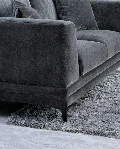 Dark grey fabric sofa with firm cushions and black legs on a textured grey rug
