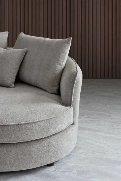 Light grey fabric round sofa chair with cushions in modern living room setting