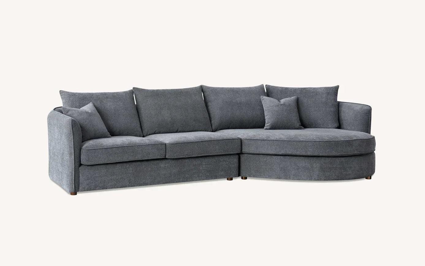 Grey corner sofa with rounded chaise and scatter cushions on light background