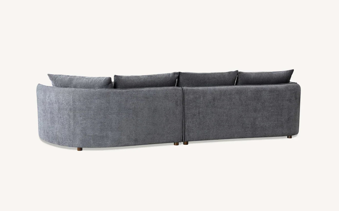 Back view of grey fabric corner sofa with loose cushions and wooden legs