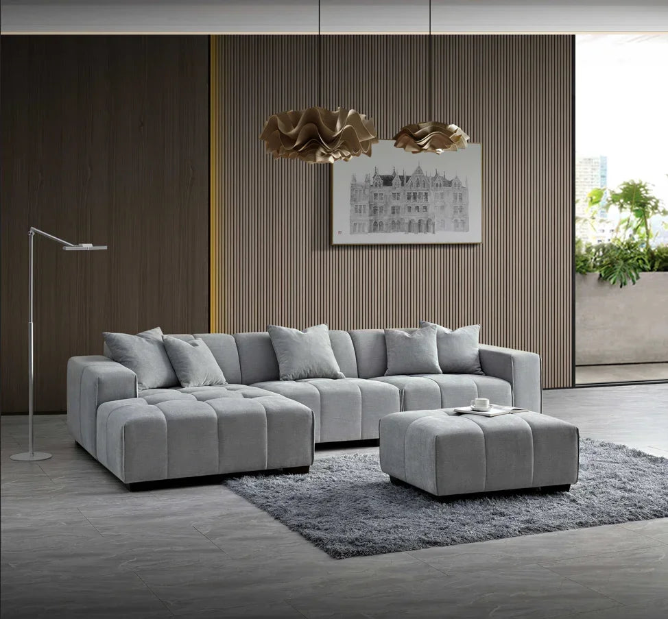 Grey corner sofa set with matching ottoman on a rug in a modern living room