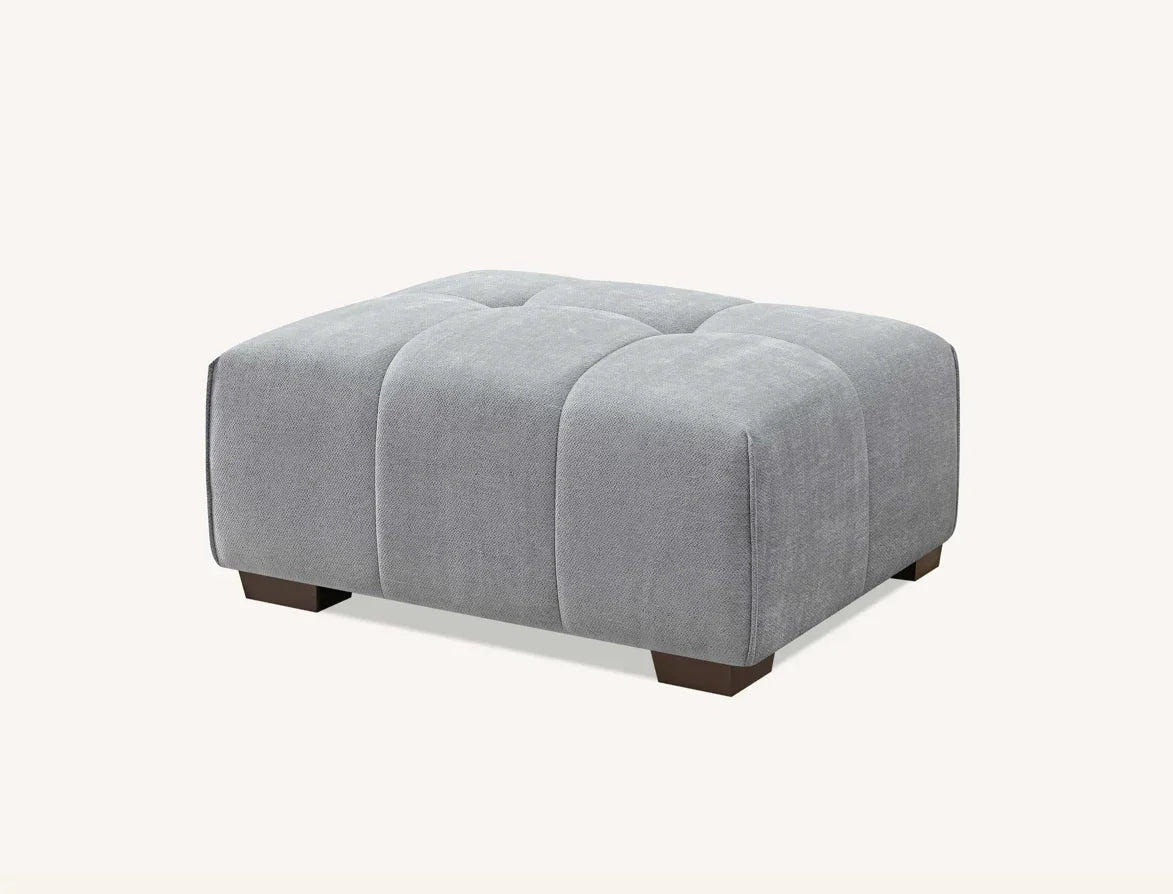 Grey upholstered ottoman footstool with tufted top and wooden feet