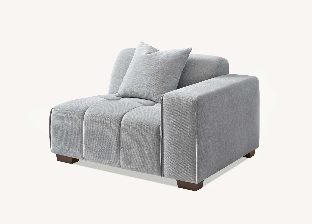 Light grey fabric armchair with wide armrest, matching cushion, and dark wood legs