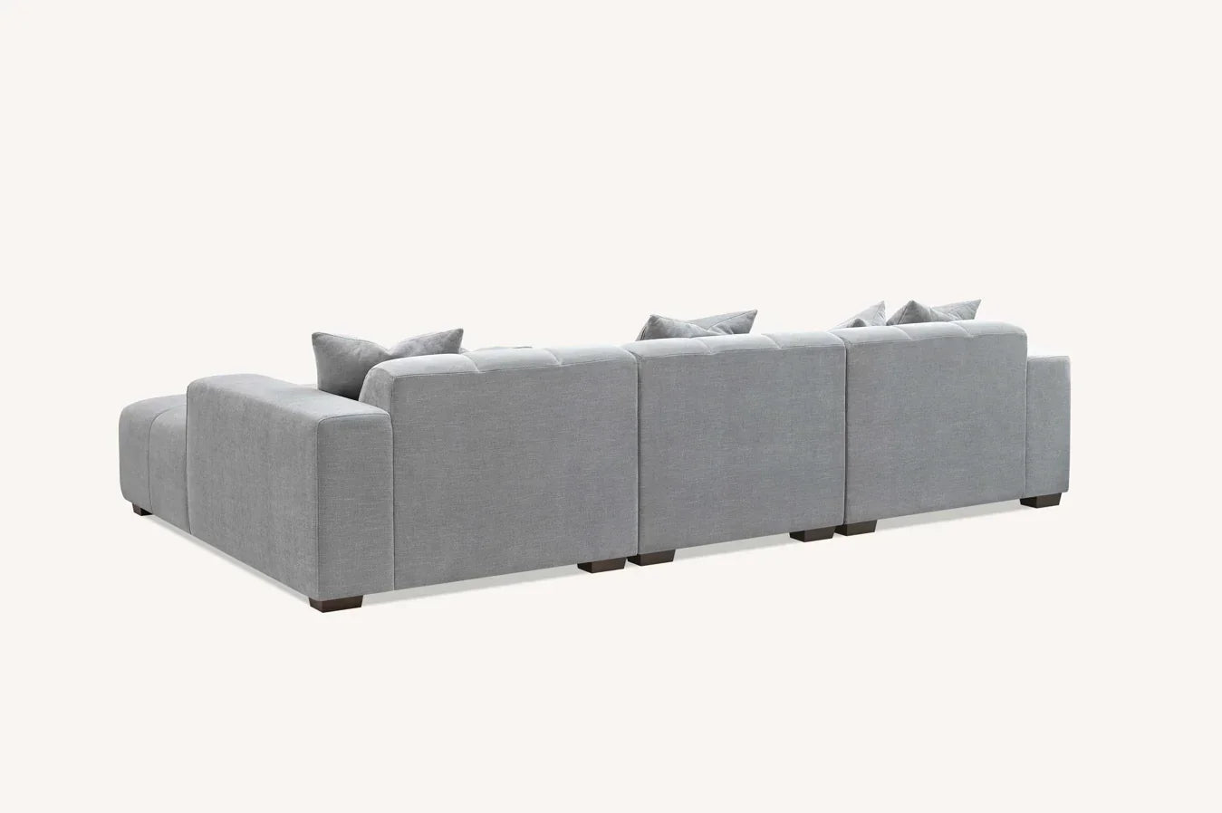 Back view of modular grey fabric corner sofa with low square arms and scatter cushions
