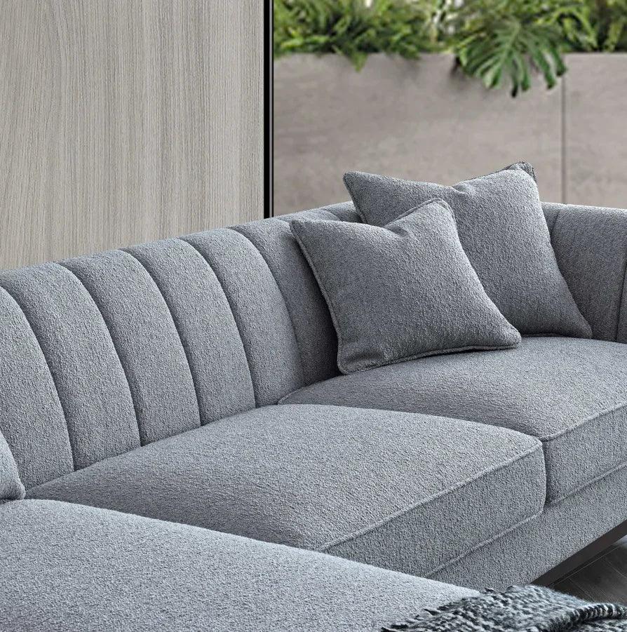 Grey fabric sofa with textured upholstery and two matching cushions in modern living room