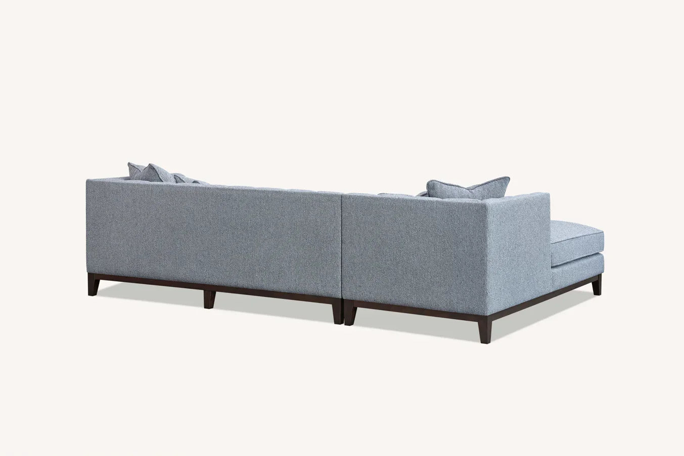 Back view of grey fabric corner sofa with chaise and dark wood legs