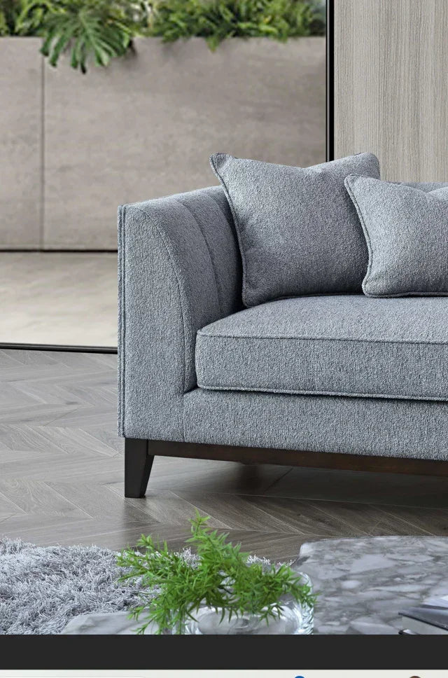 Grey fabric sofa with square armrest, matching cushions, wooden legs, living room setting