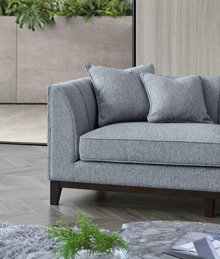 Grey fabric sofa with wooden legs and cushions in modern living room