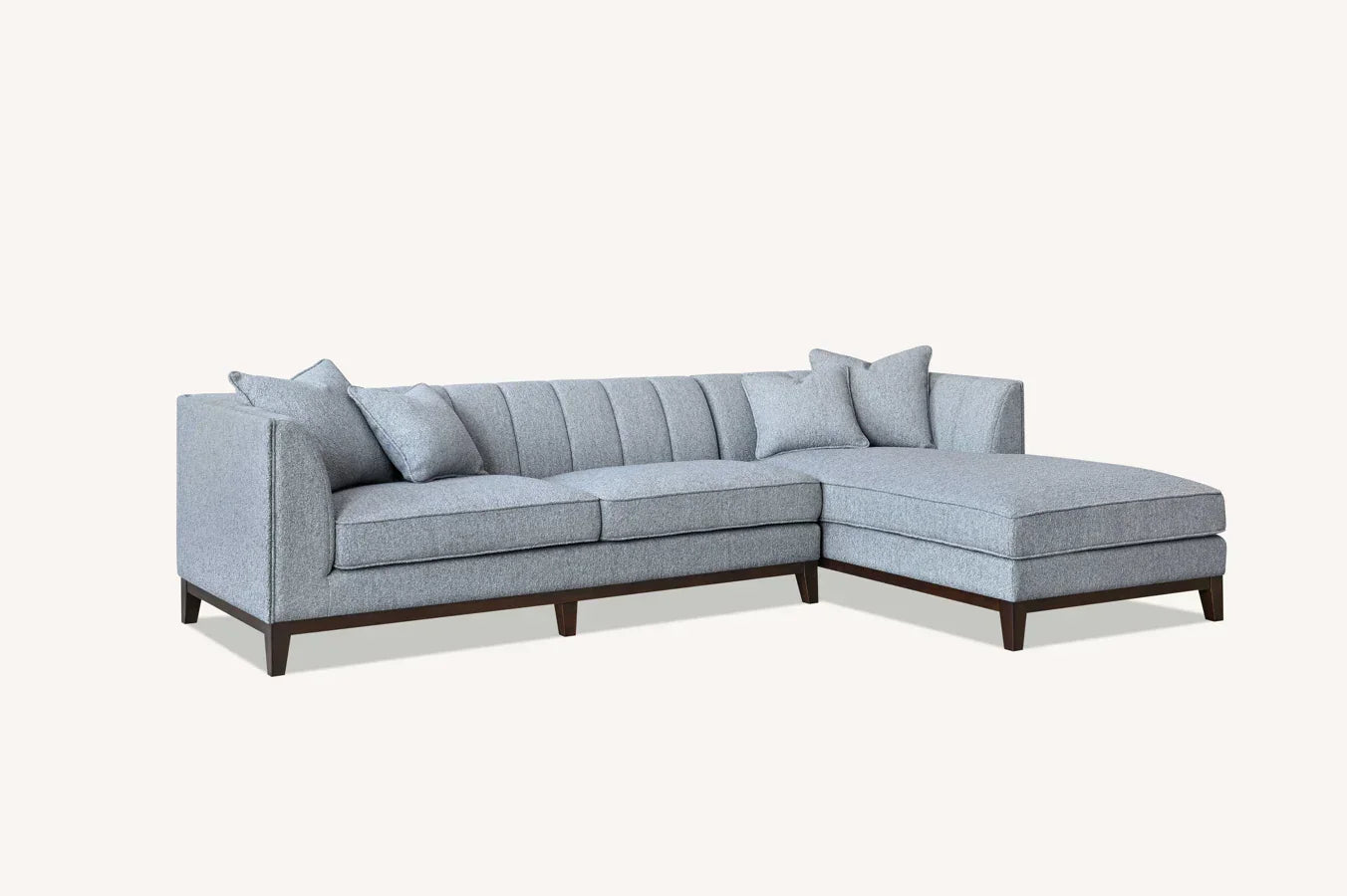 Grey corner sofa with chaise lounge and scatter cushions on dark wood legs