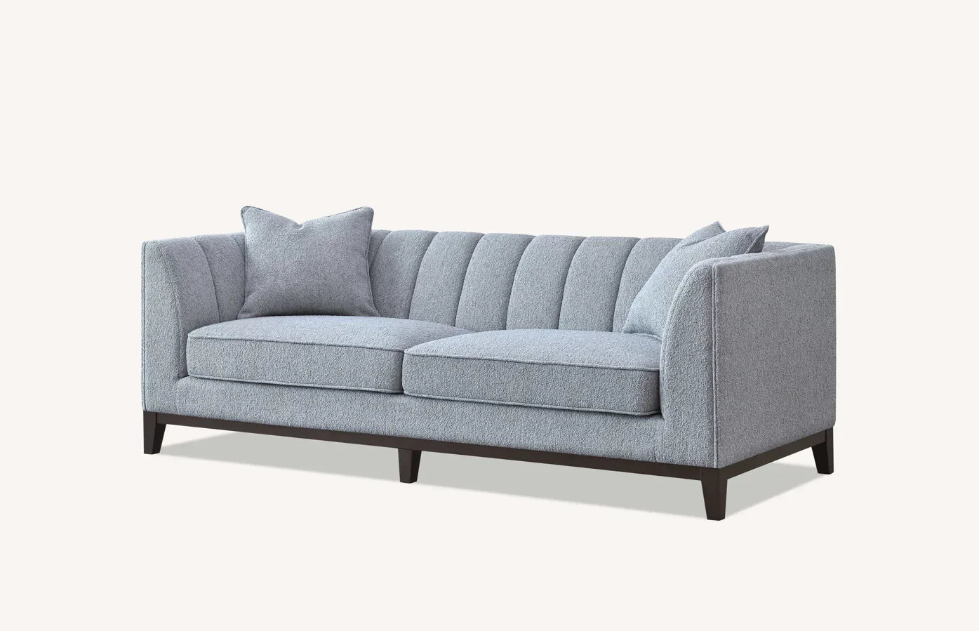 Grey fabric sofa with channel tufted back, two seat cushions and matching throw pillows