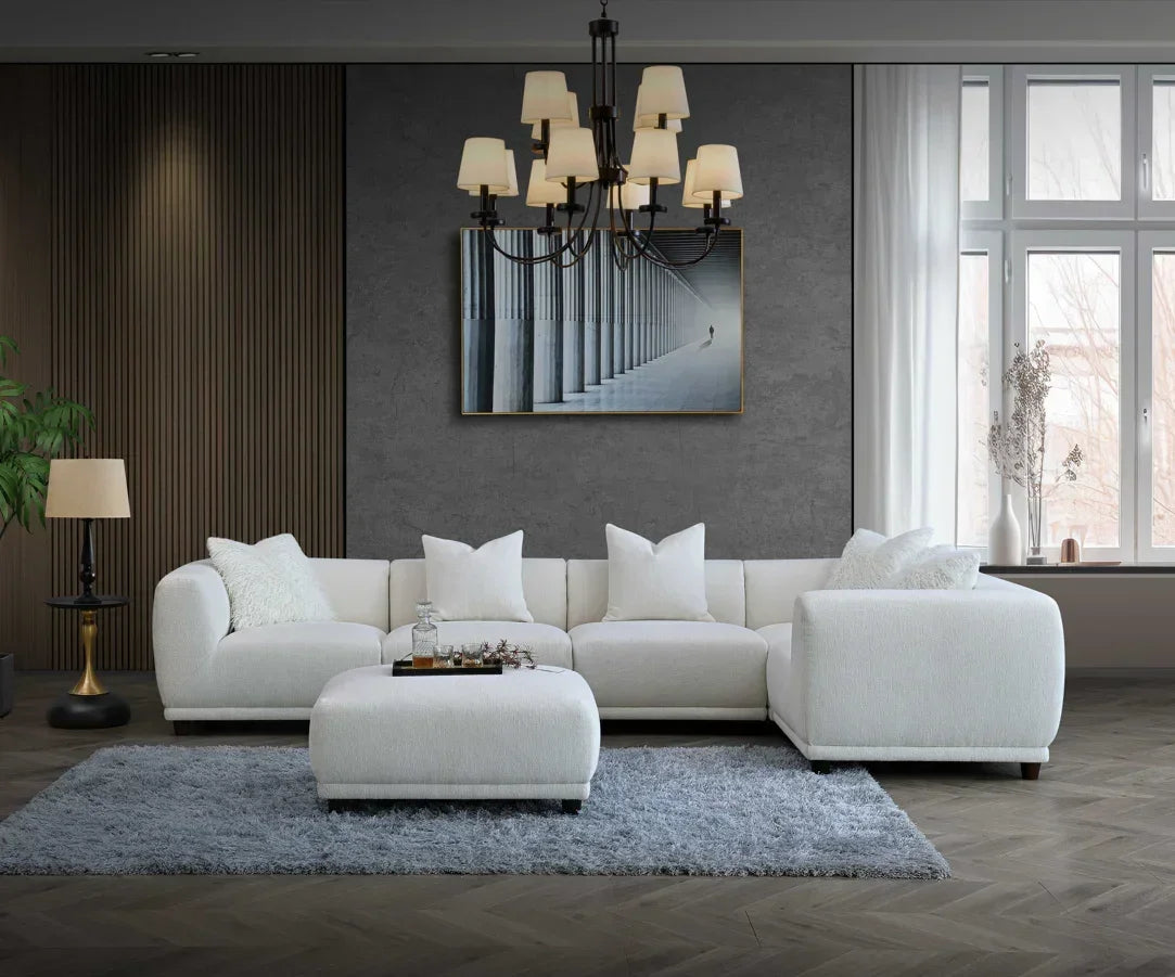 White corner sofa with matching ottoman on grey rug in modern living room