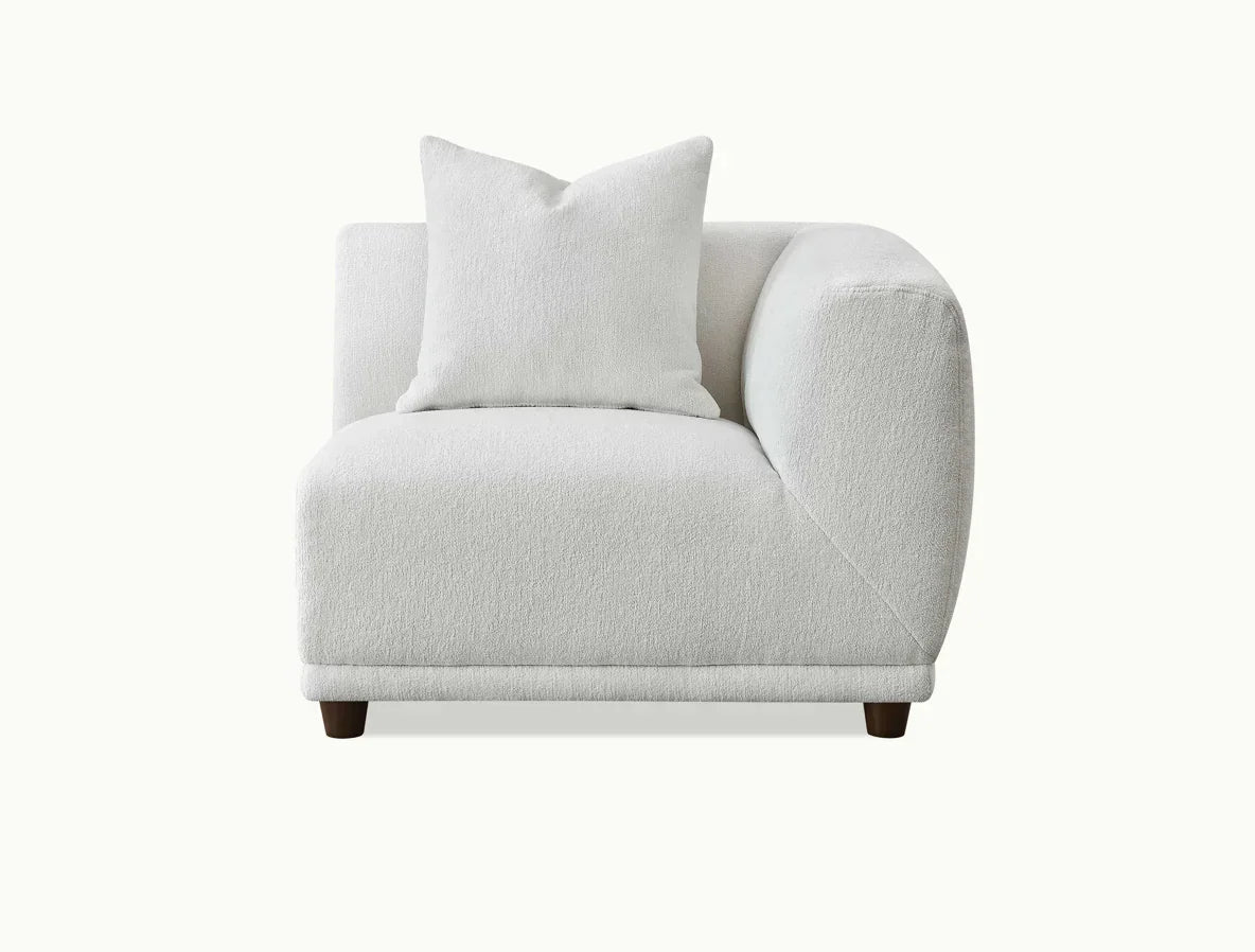 Modern corner sofa seat in white fabric with matching cushion, front view