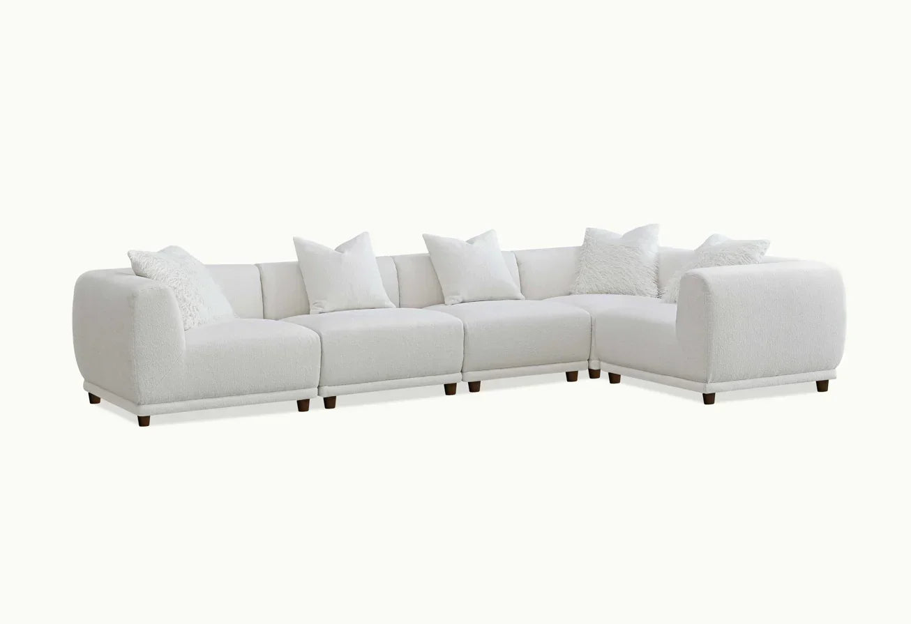 Modern white corner sofa with plush cushions and low wooden legs