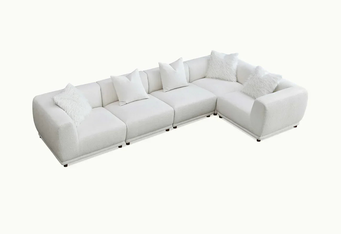 Modern white corner sofa with plush cushions and soft upholstery on plain background