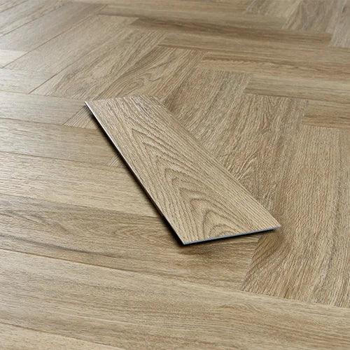 Light oak effect laminate flooring panel on herringbone patterned wood floor