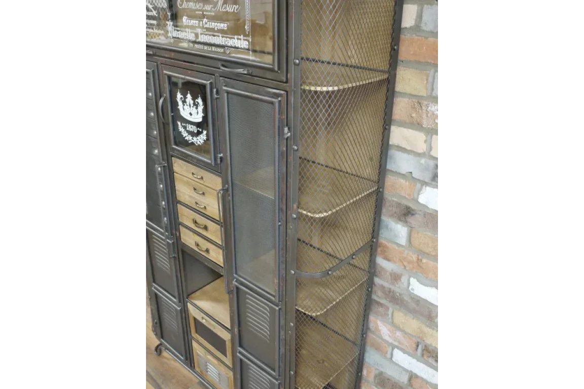 Industrial storage cabinet with metal mesh doors, wood drawers and shelving against brick wall