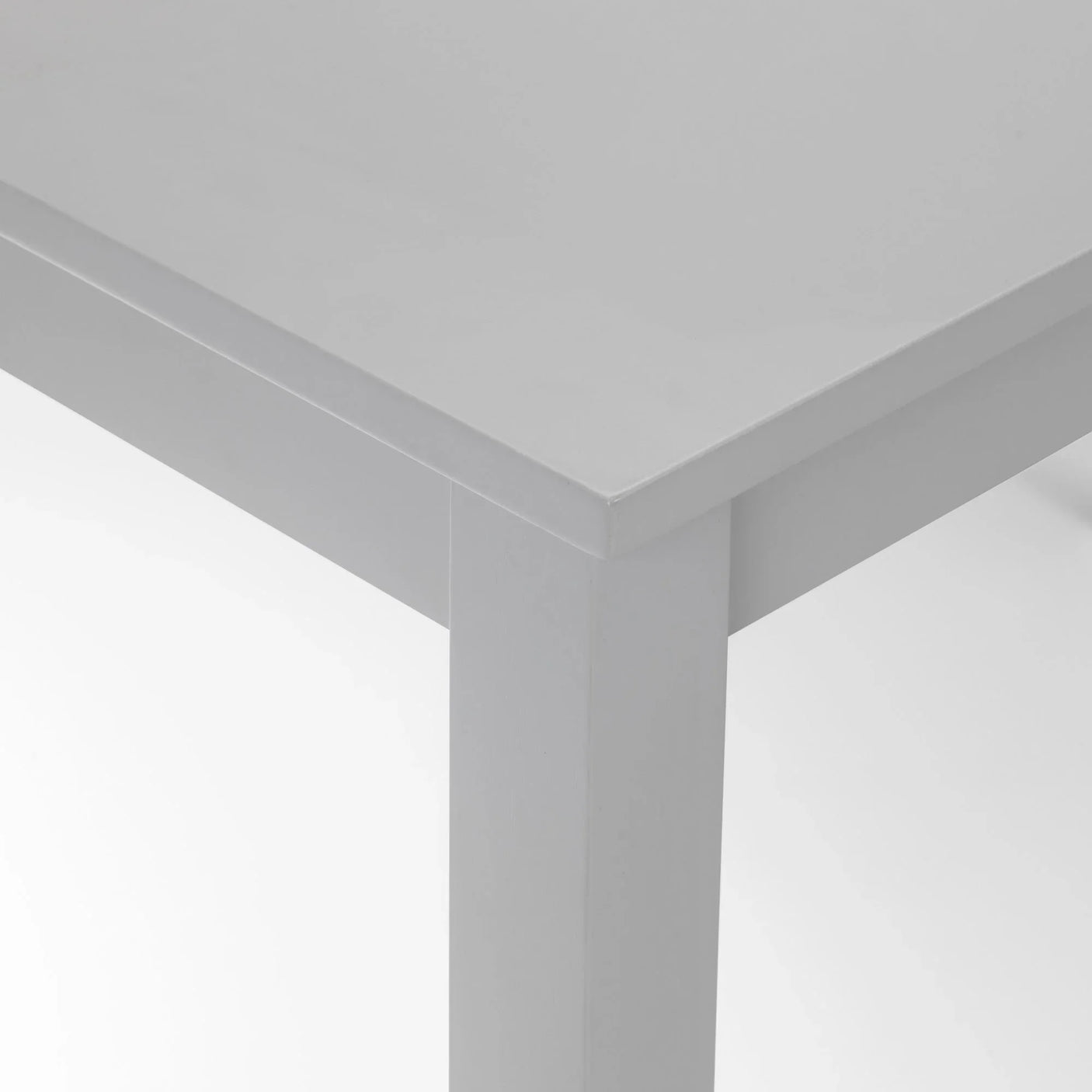 Closeup of grey wooden dining table corner with square leg