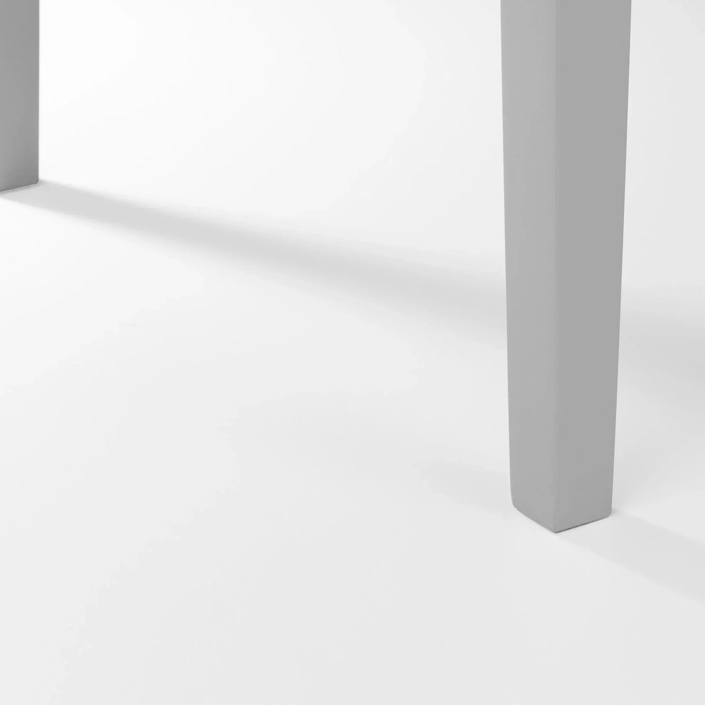 Close view of grey dining table legs on white background