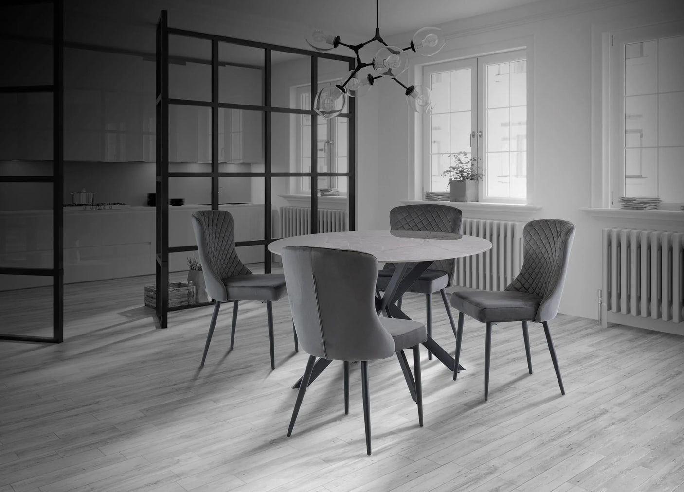 Modern round dining table with four grey upholstered chairs in contemporary dining room