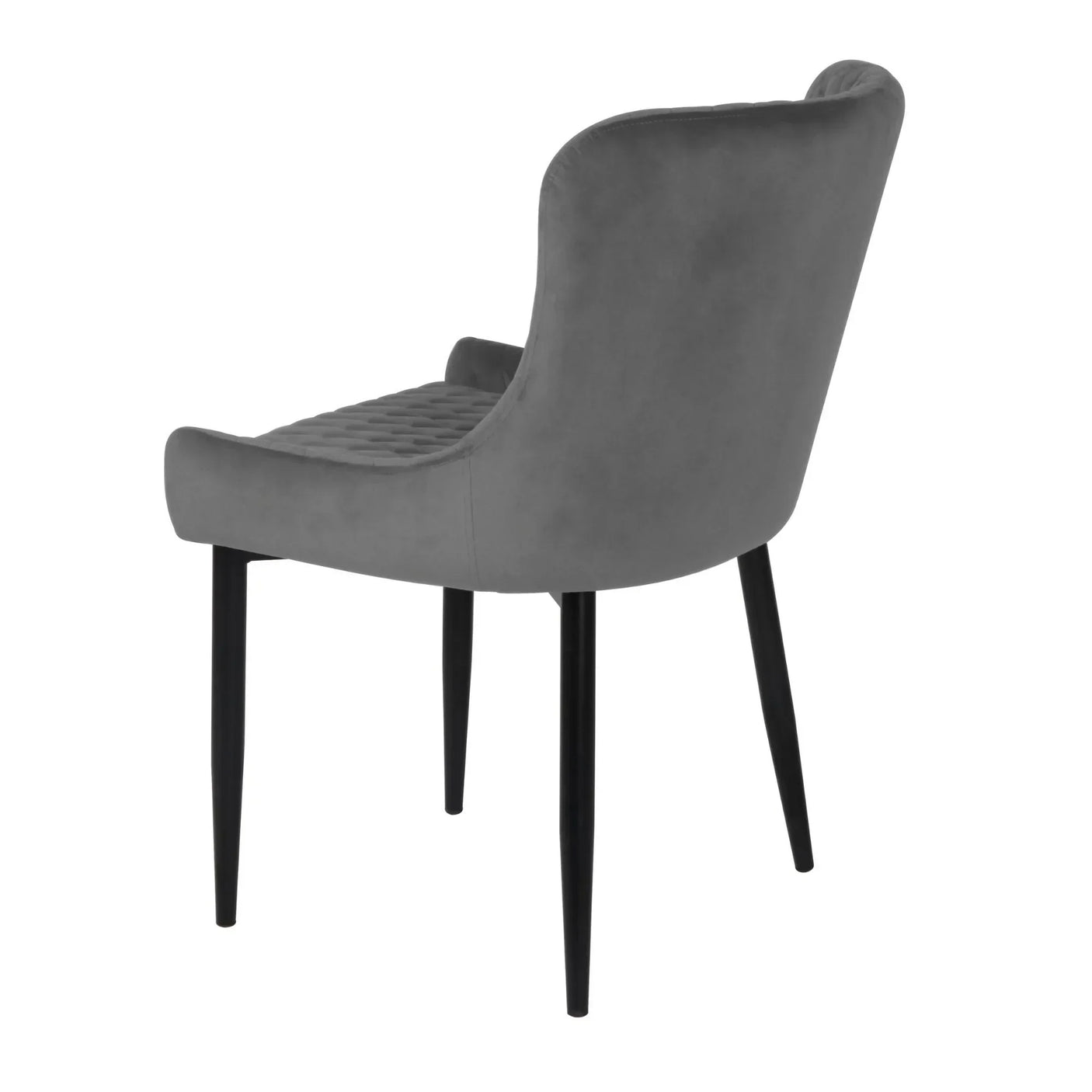 Grey velvet dining chair with curved backrest and quilted seat, angled rear view