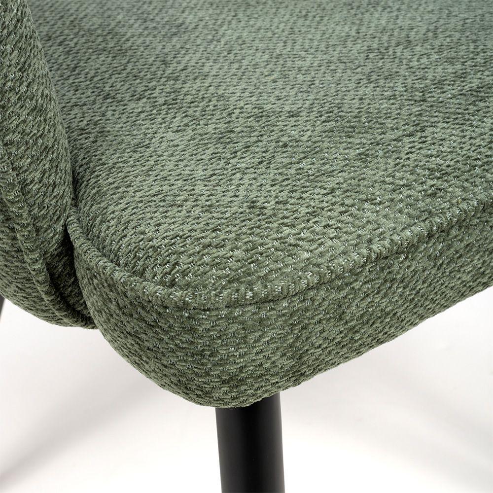 Textured green fabric dining chair seat detail with black metal leg