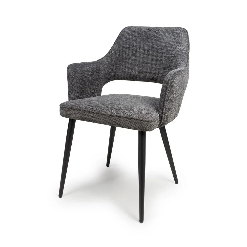 Grey fabric dining chair with curved backrest and black metal legs on white background
