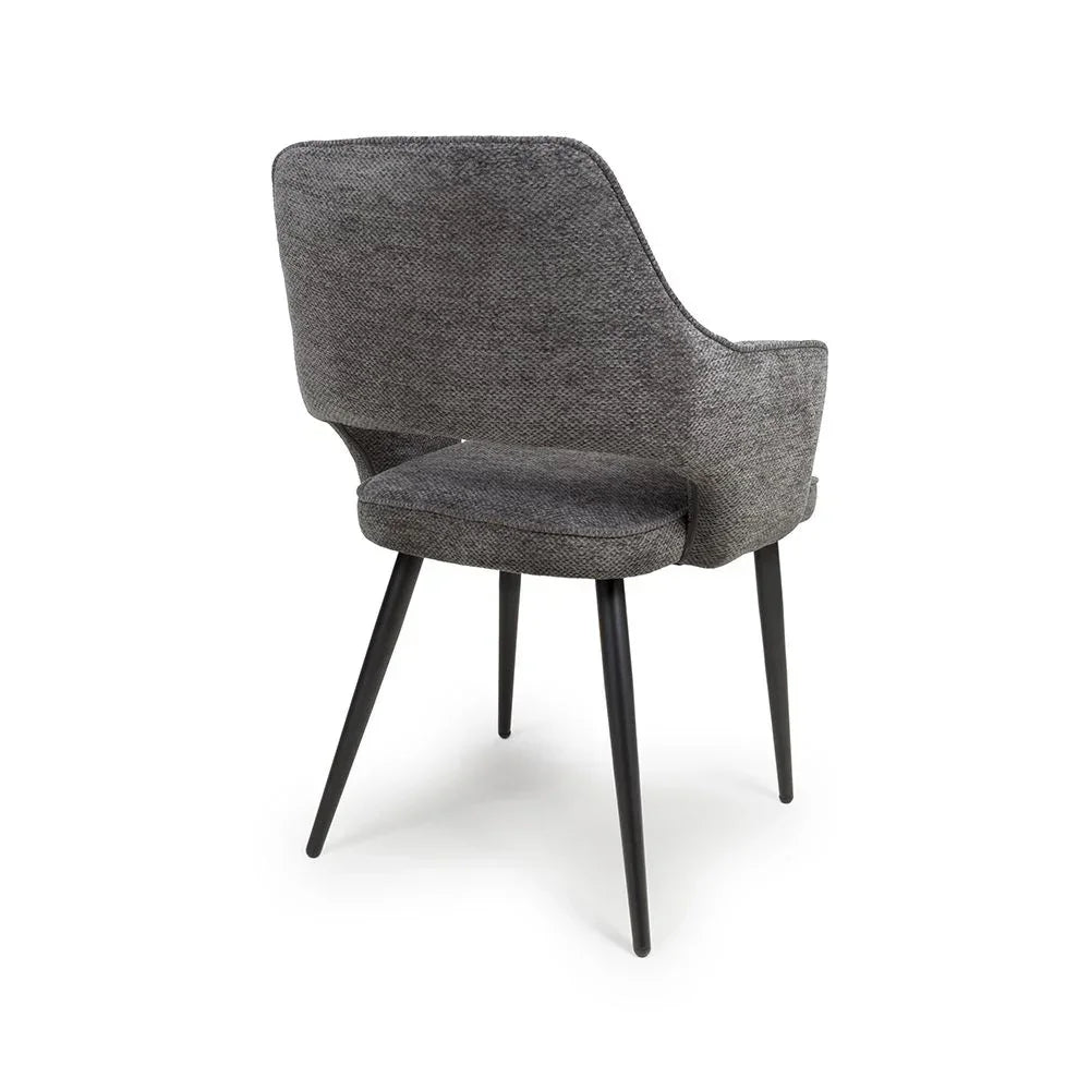 Grey fabric dining chair with black tapered legs, angled rear view showing cushioned back