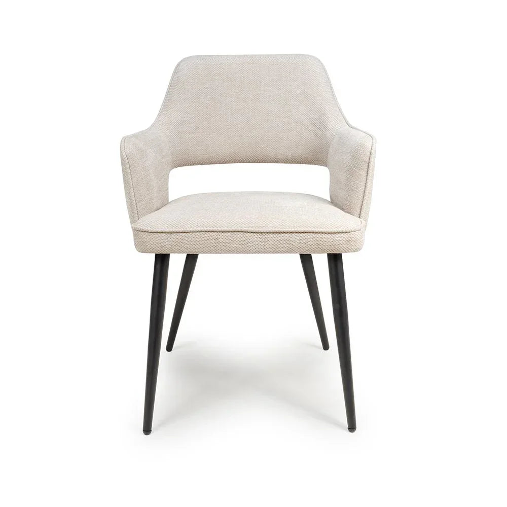 Beige fabric dining chair with black metal legs and open backrest, front view