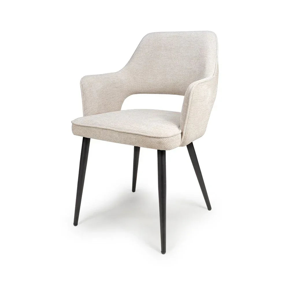 Beige fabric dining chair with curved backrest and black tapered metal legs