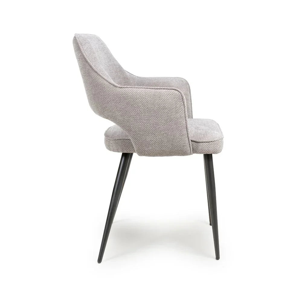Grey fabric dining chair with curved backrest and black angled legs, side profile view